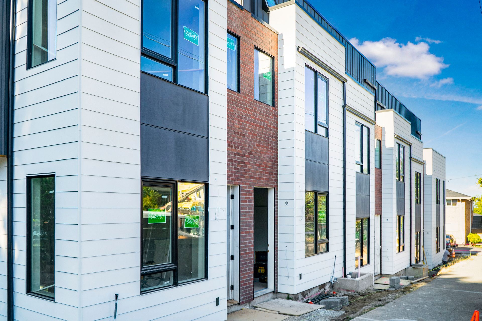 A row of apartment buildings under construction with a lot of windows.