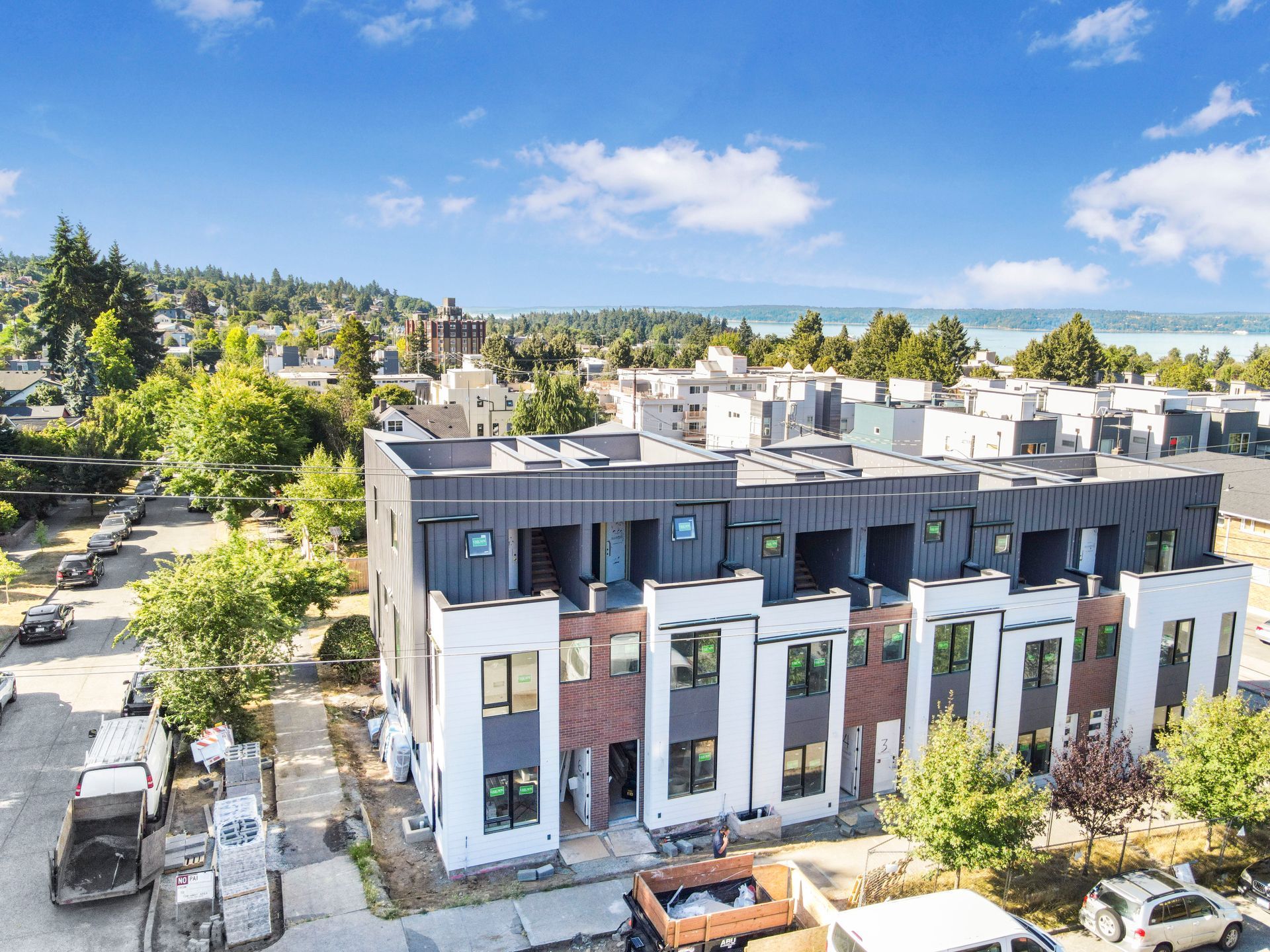 An aerial view of a building under construction with trucks parked in front of it.
