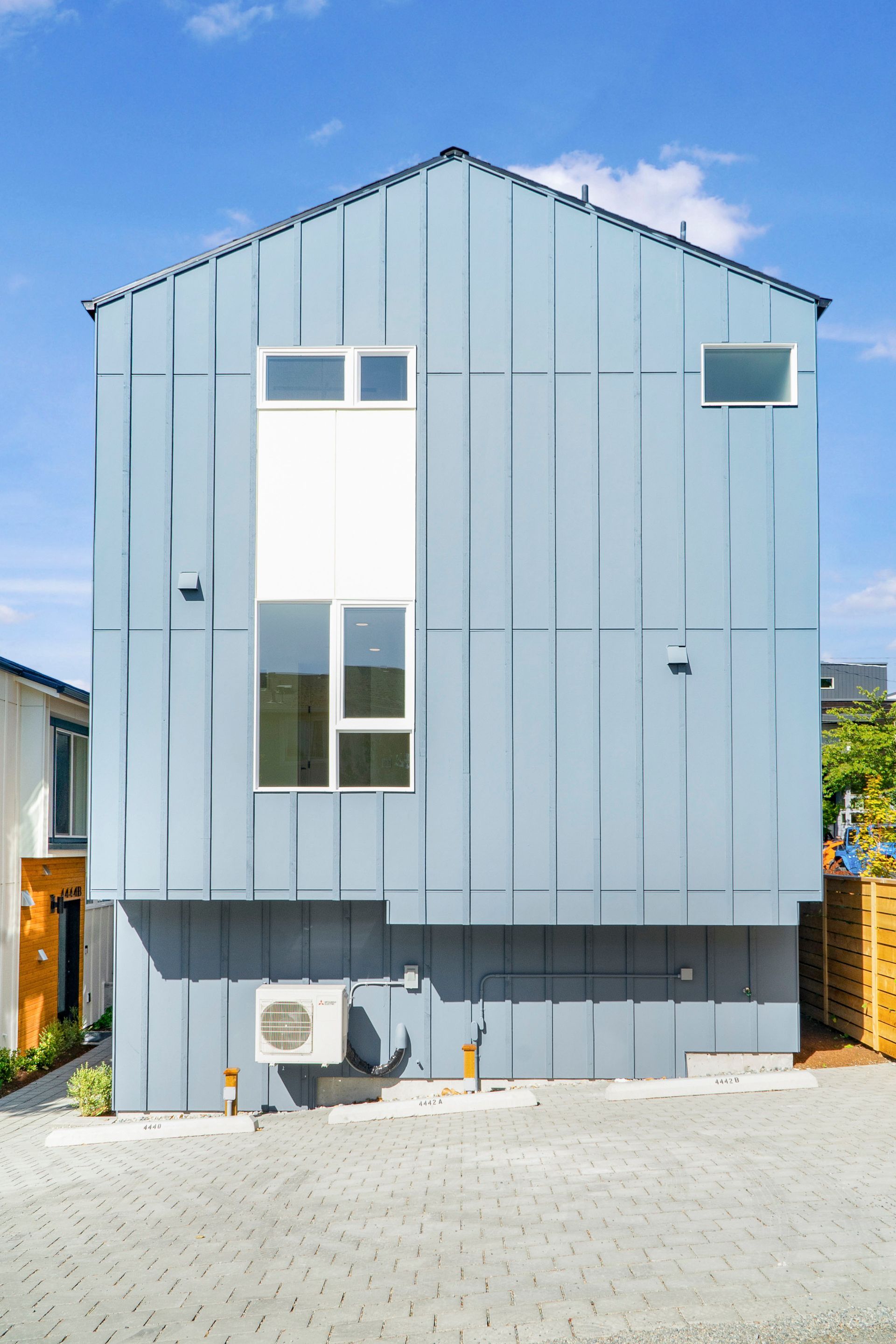 A blue house with a white roof and a lot of windows.