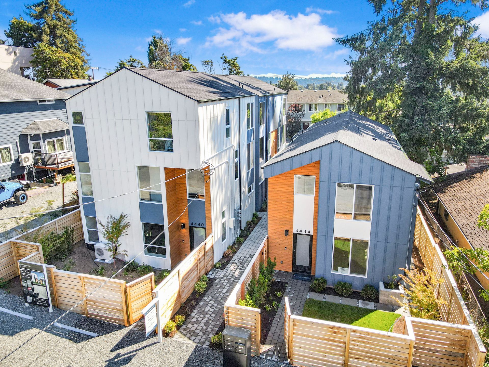 An aerial view of a row of houses with a wooden fence surrounding them.