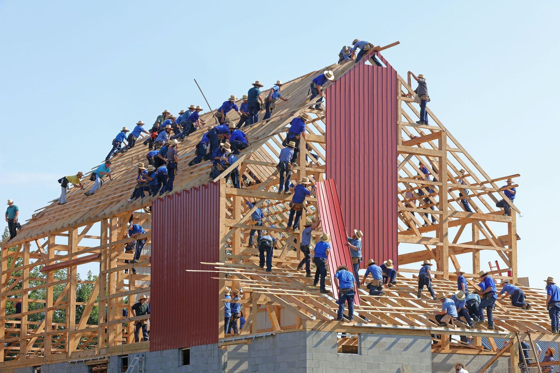 A large group of people are working on a wooden structure.