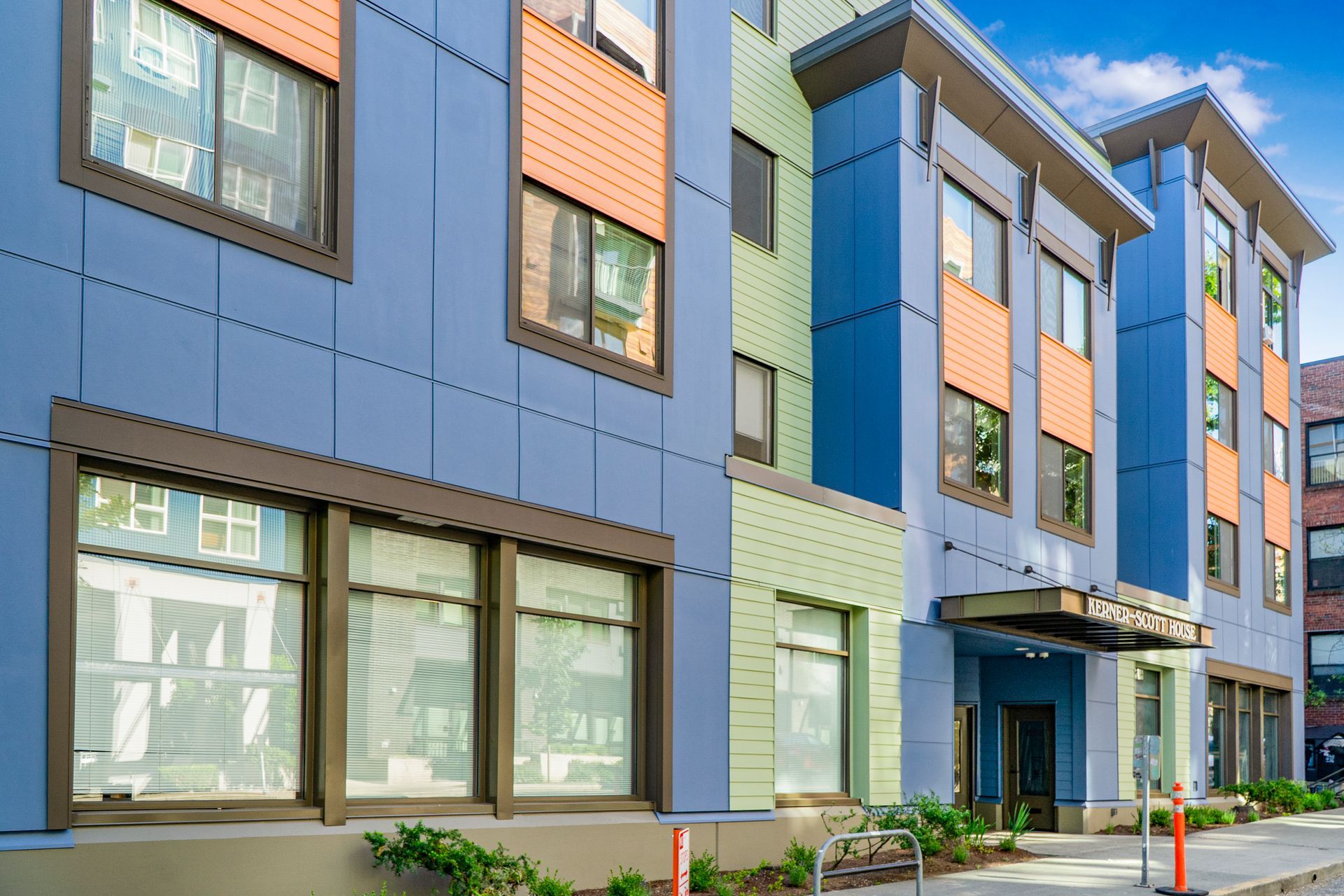 A blue and orange apartment building with a lot of windows
