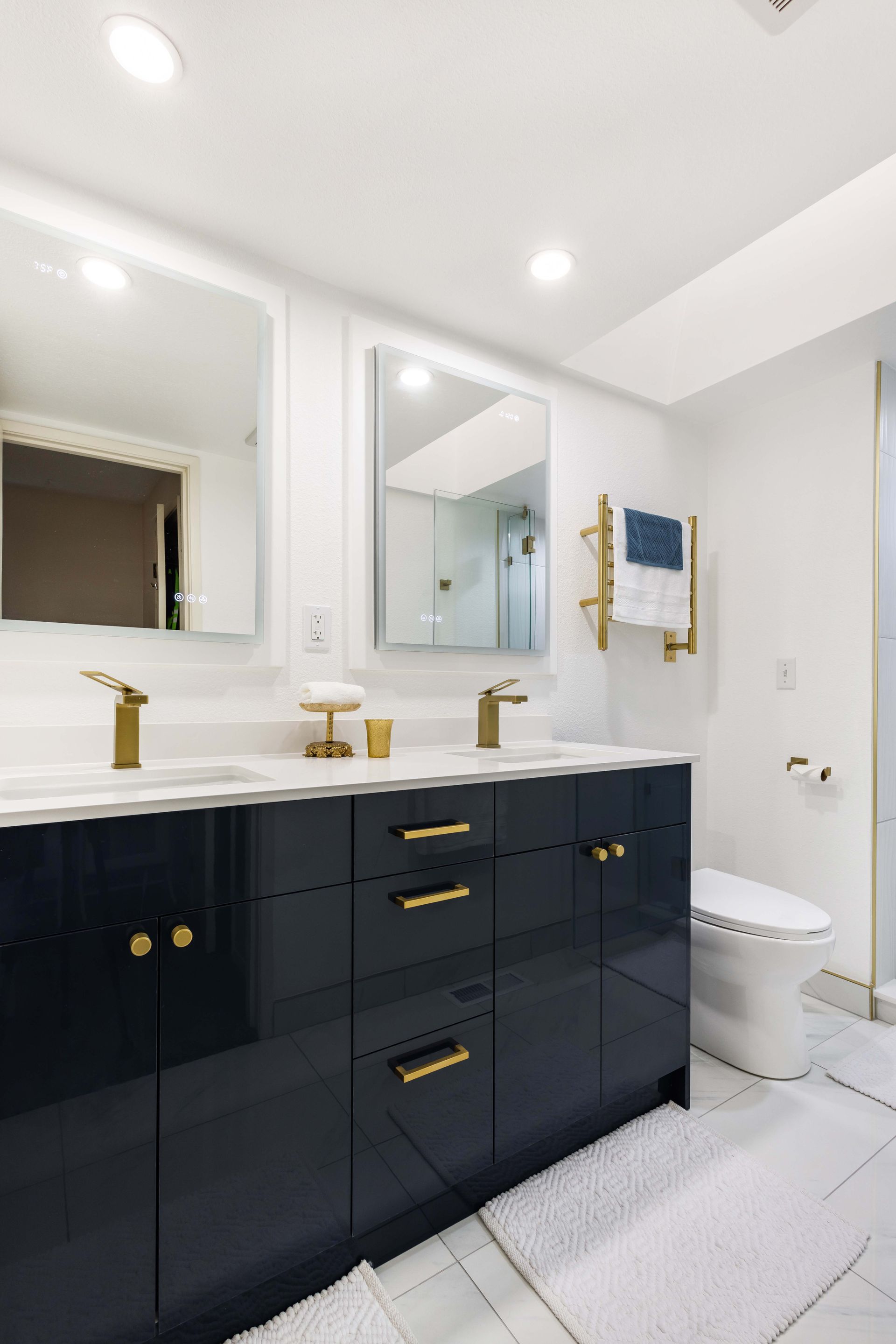 A bathroom with two sinks , a toilet , and a mirror.