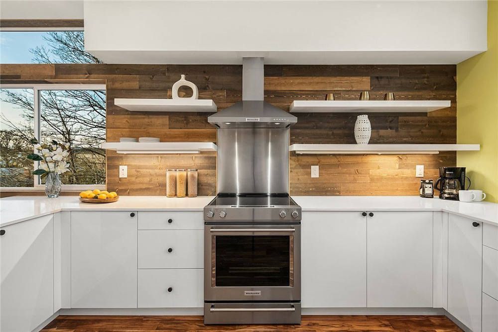 A kitchen with stainless steel appliances and white cabinets.