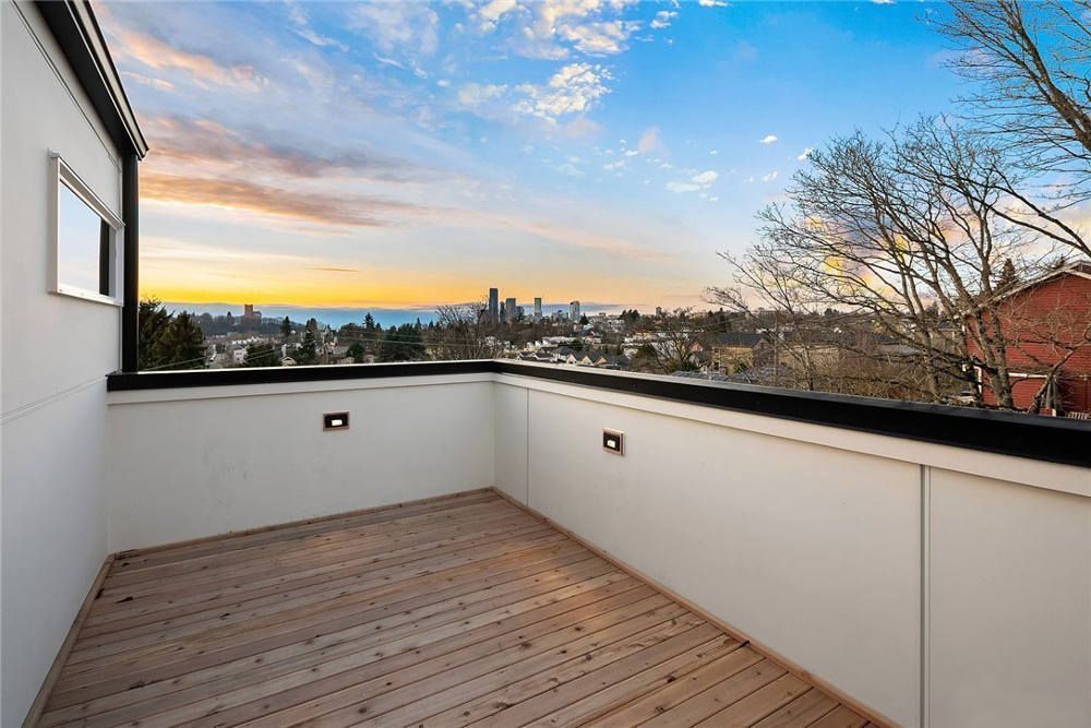 There is a balcony with a view of the city and the ocean.