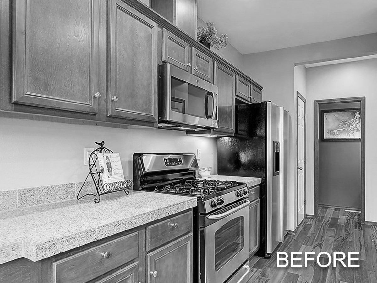 A black and white photo of a kitchen with stainless steel appliances.