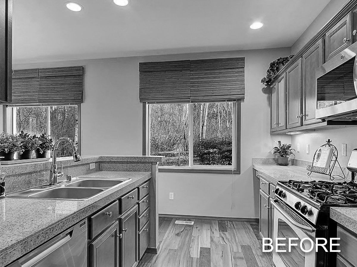 A black and white photo of a kitchen before a remodel.