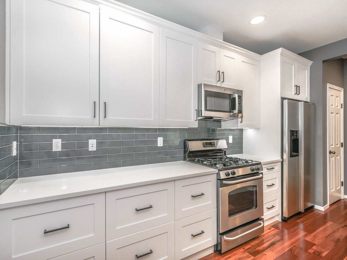 A kitchen with white cabinets and stainless steel appliances.