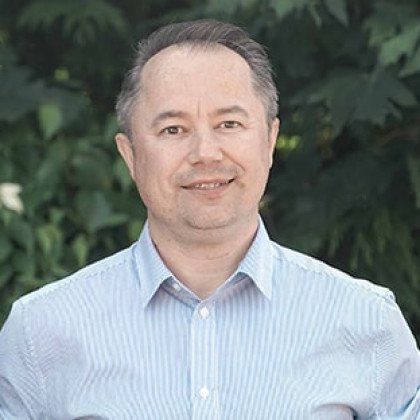 A man in a blue striped shirt is smiling for the camera.