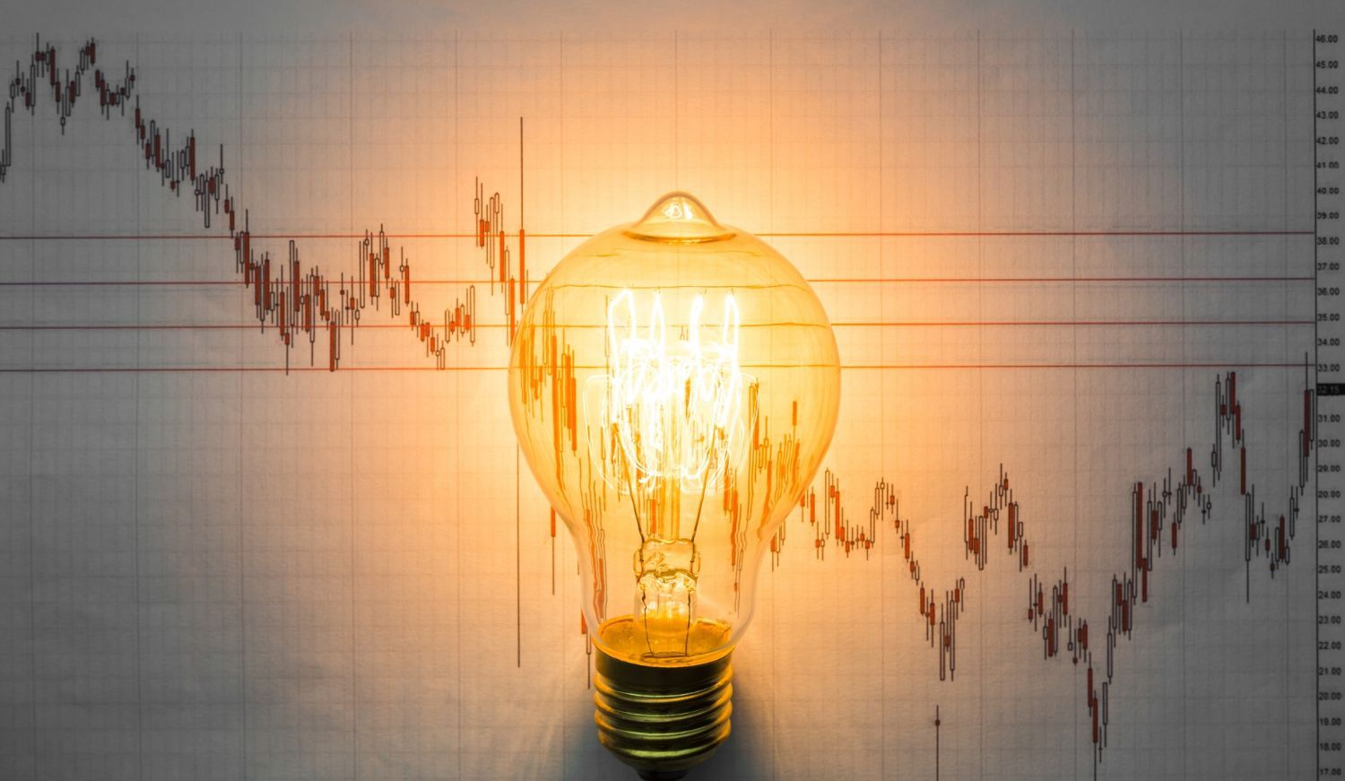 A light bulb is lit up in front of a graph.