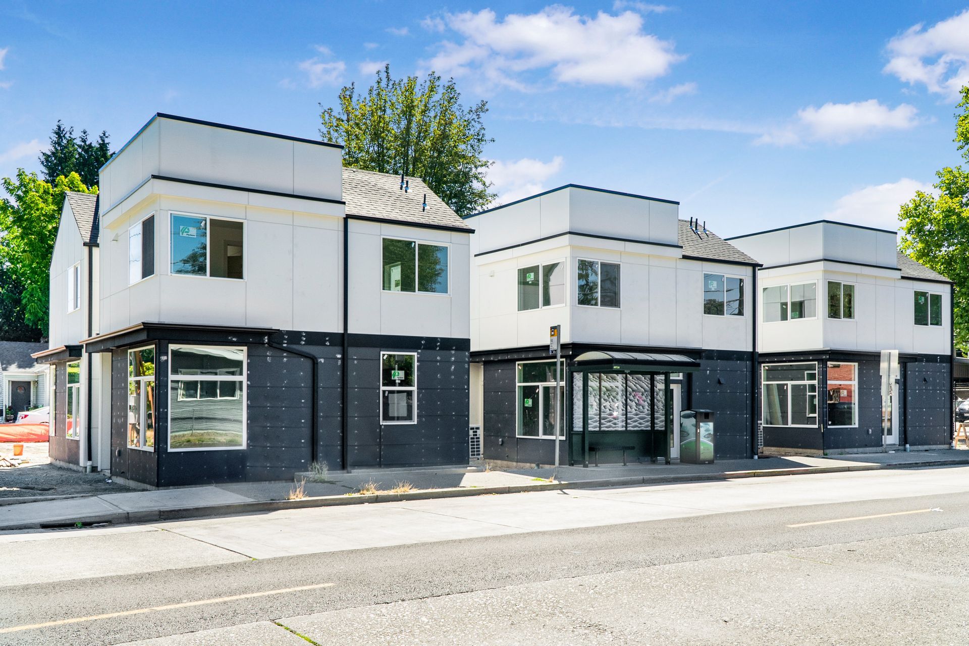 A row of buildings are sitting next to each other on the side of a road.