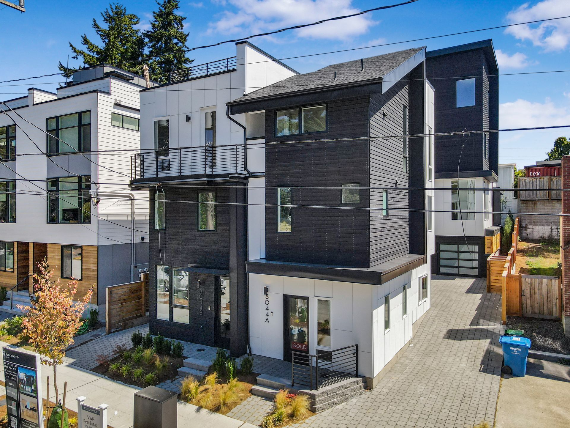 An aerial view of a black and white house with a lot of windows.