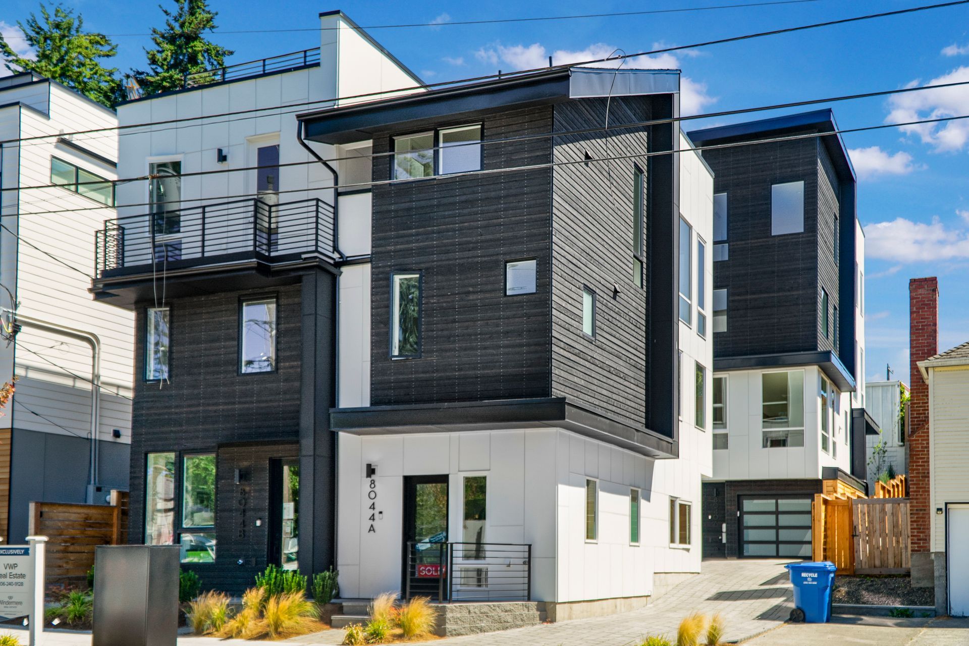 A row of modern houses are sitting next to each other on a sunny day.