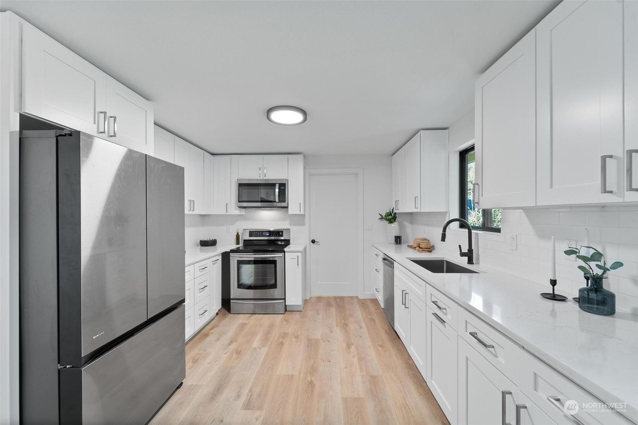 A kitchen with white cabinets and stainless steel appliances