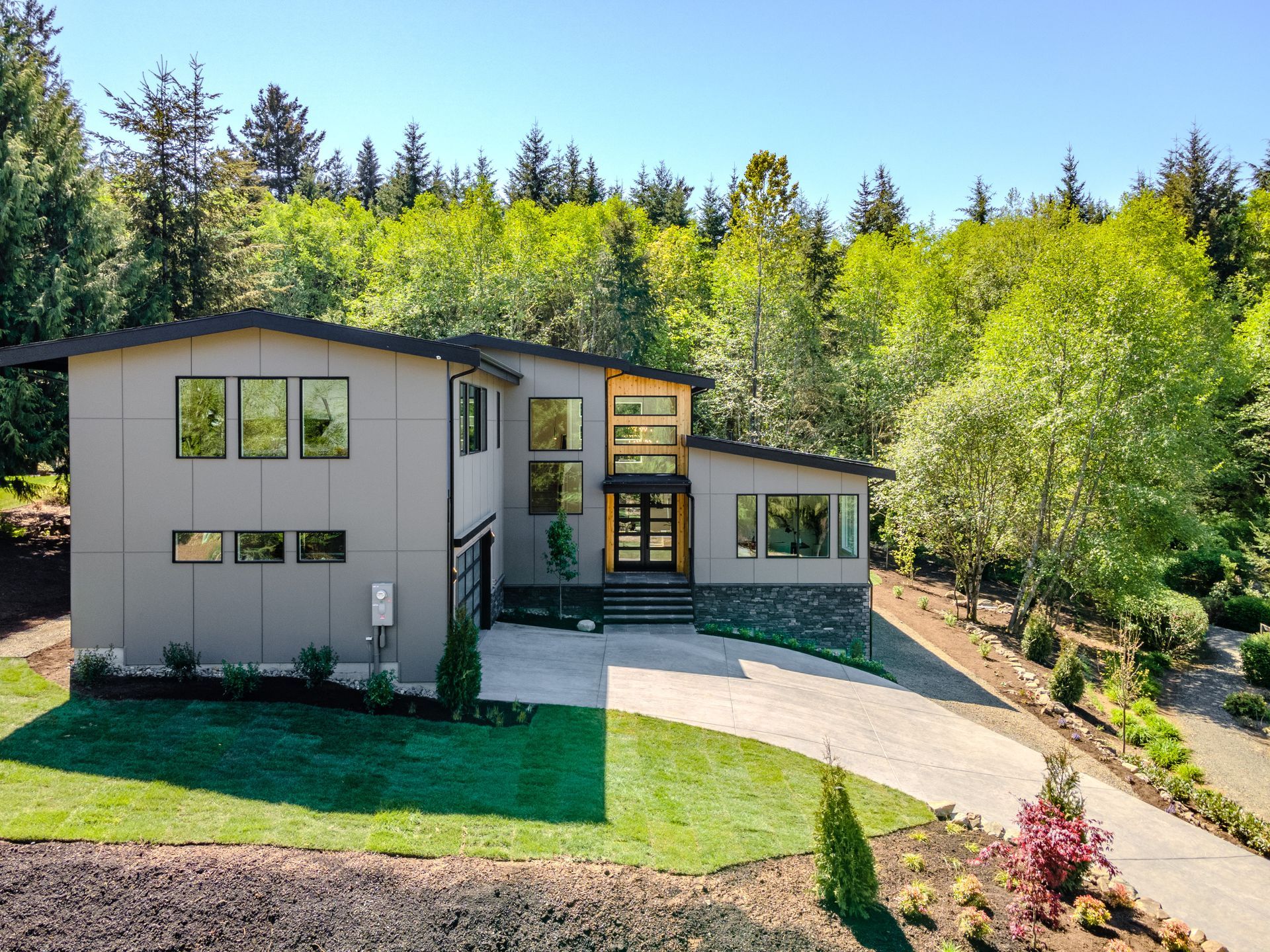 A large house with a lot of windows is surrounded by trees.