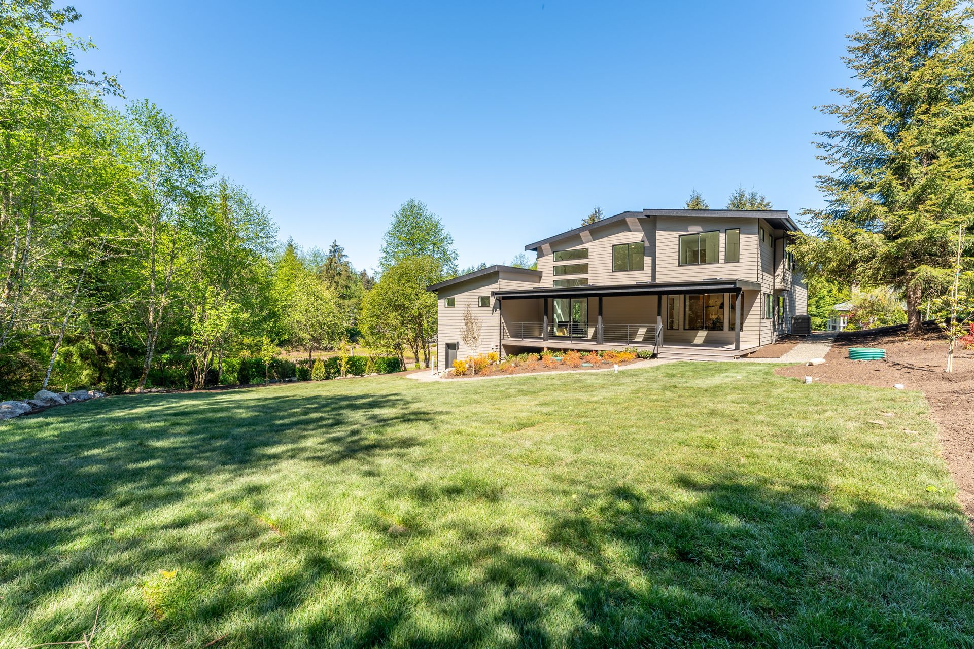 A large house with a large lawn in front of it surrounded by trees.