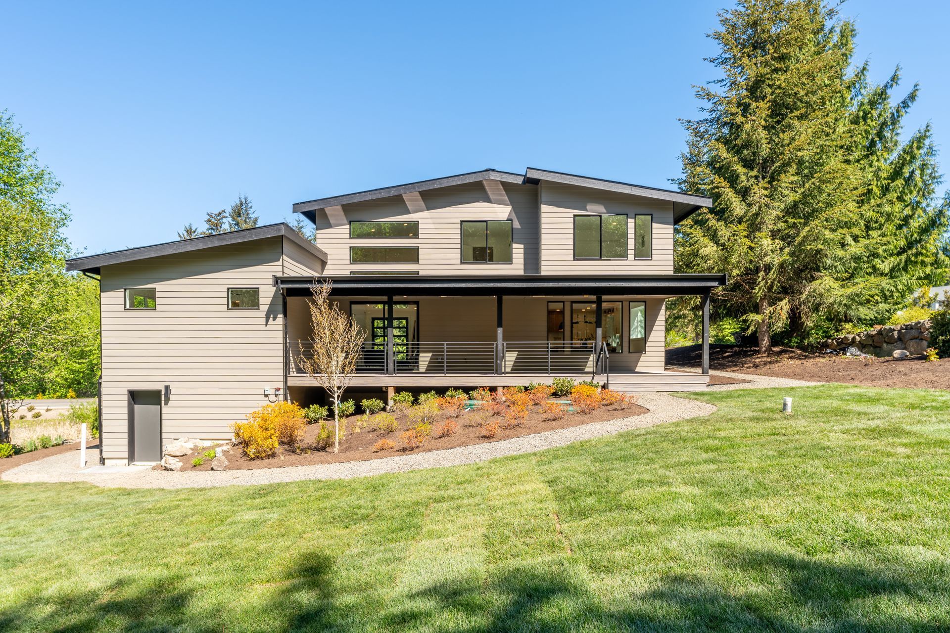 A large house is sitting on top of a lush green field.