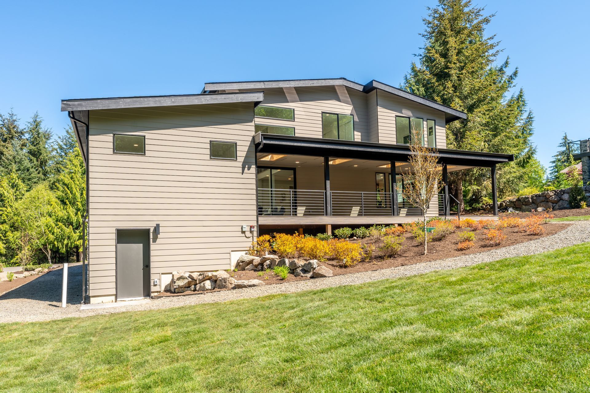 A large house is sitting on top of a lush green hillside.