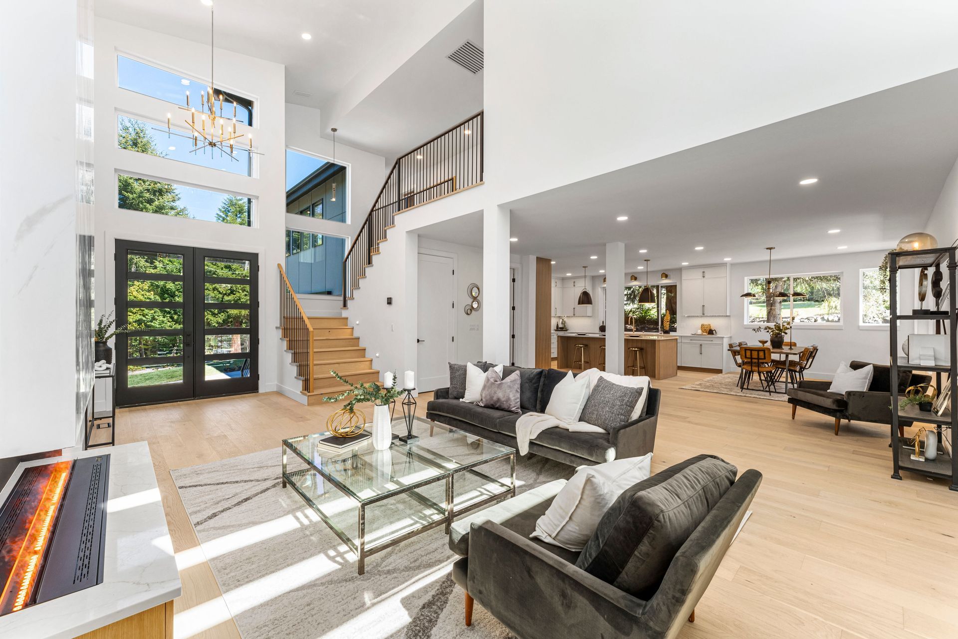 A living room with a couch , chair , coffee table and stairs.