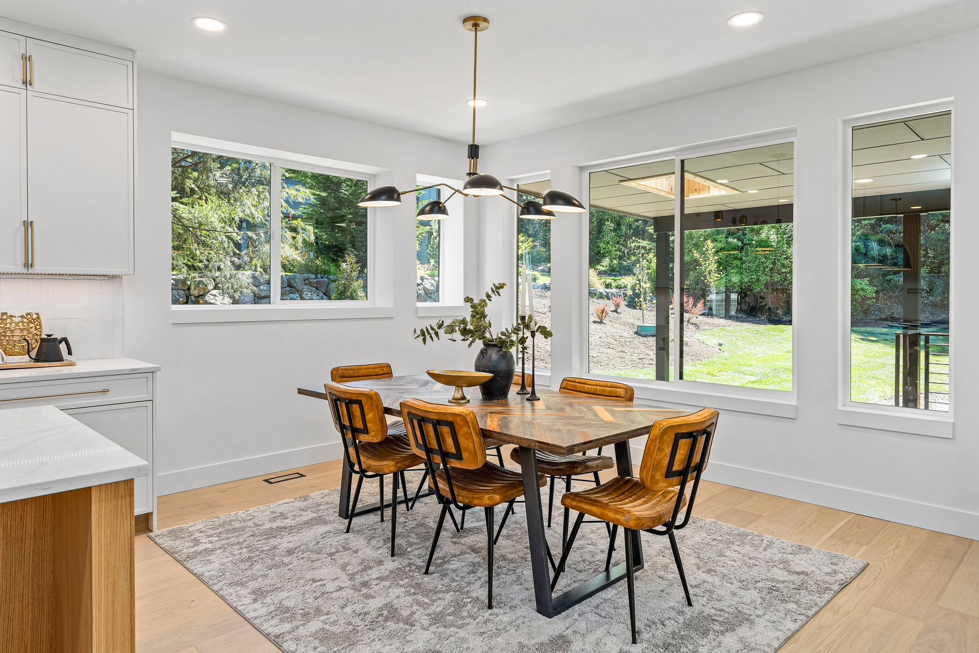 A dining room with a wooden table and chairs and a rug.