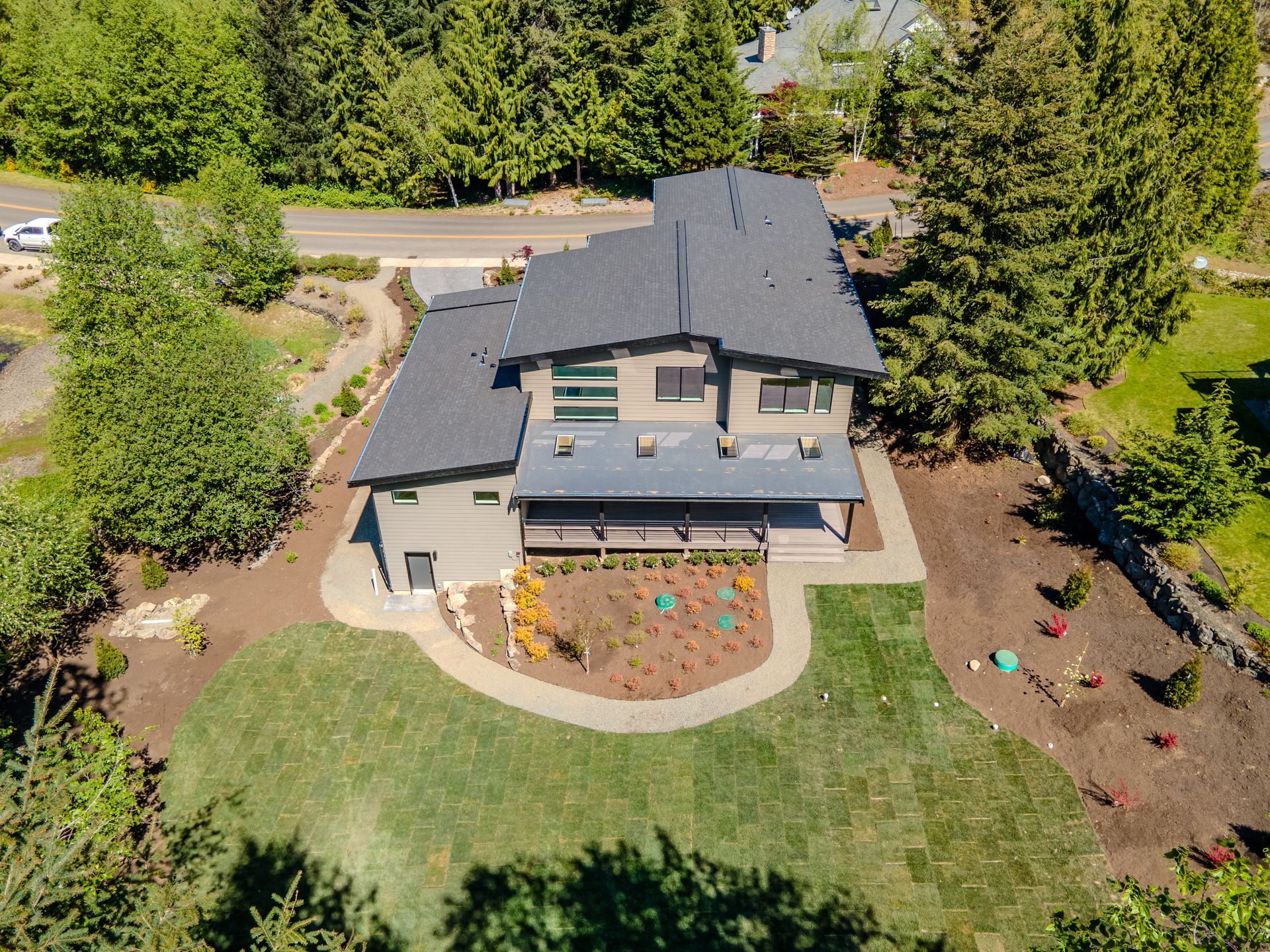 An aerial view of a large house surrounded by trees and grass.