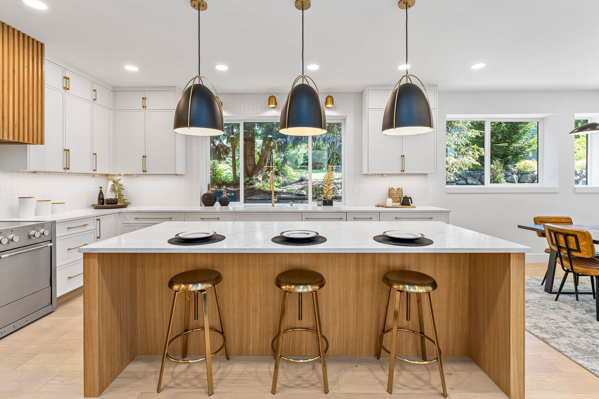 A kitchen with a large island and three stools.
