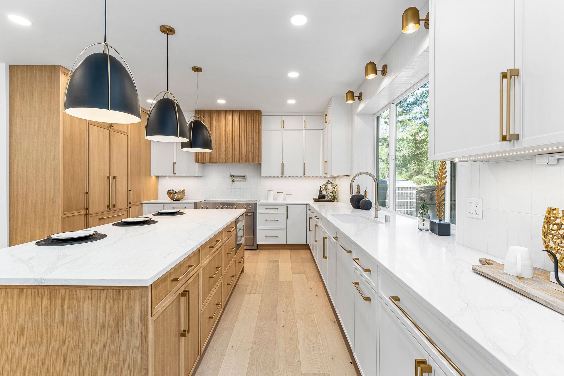A kitchen with white cabinets and wooden cabinets and a large island.
