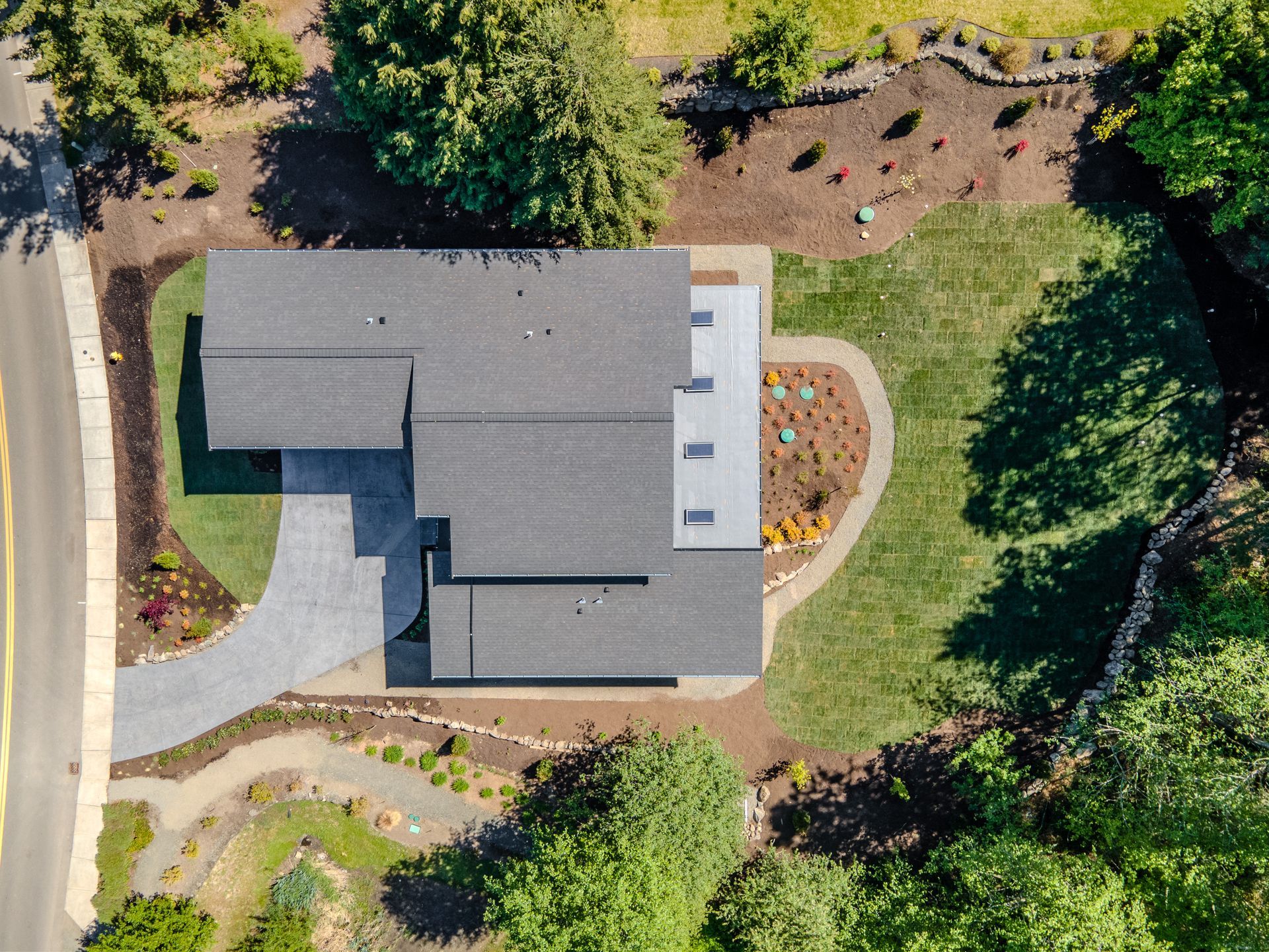 An aerial view of a house surrounded by trees and grass