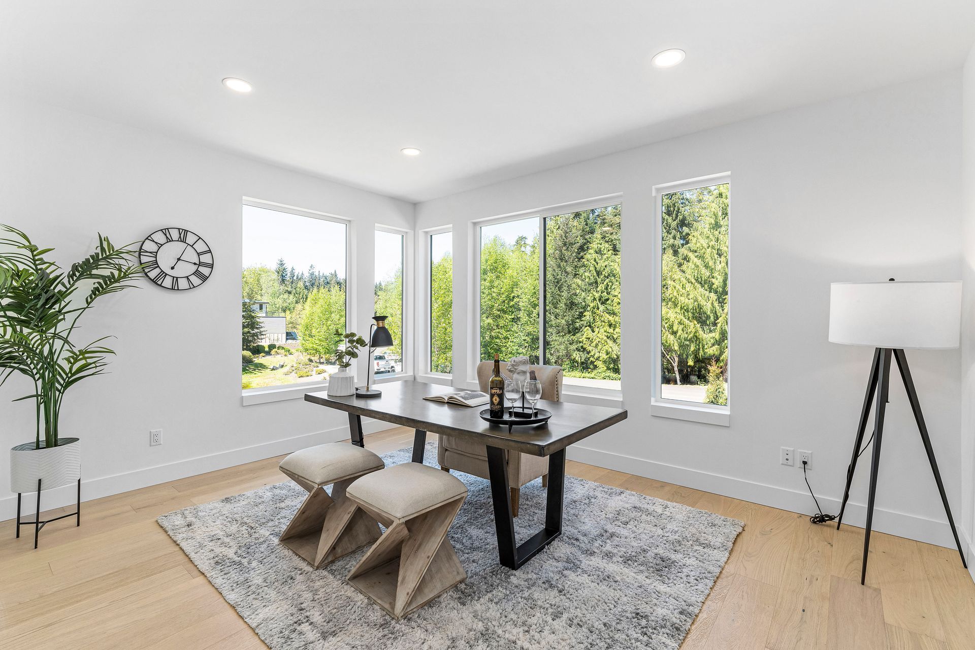 A dining room with a table and chairs and a rug.