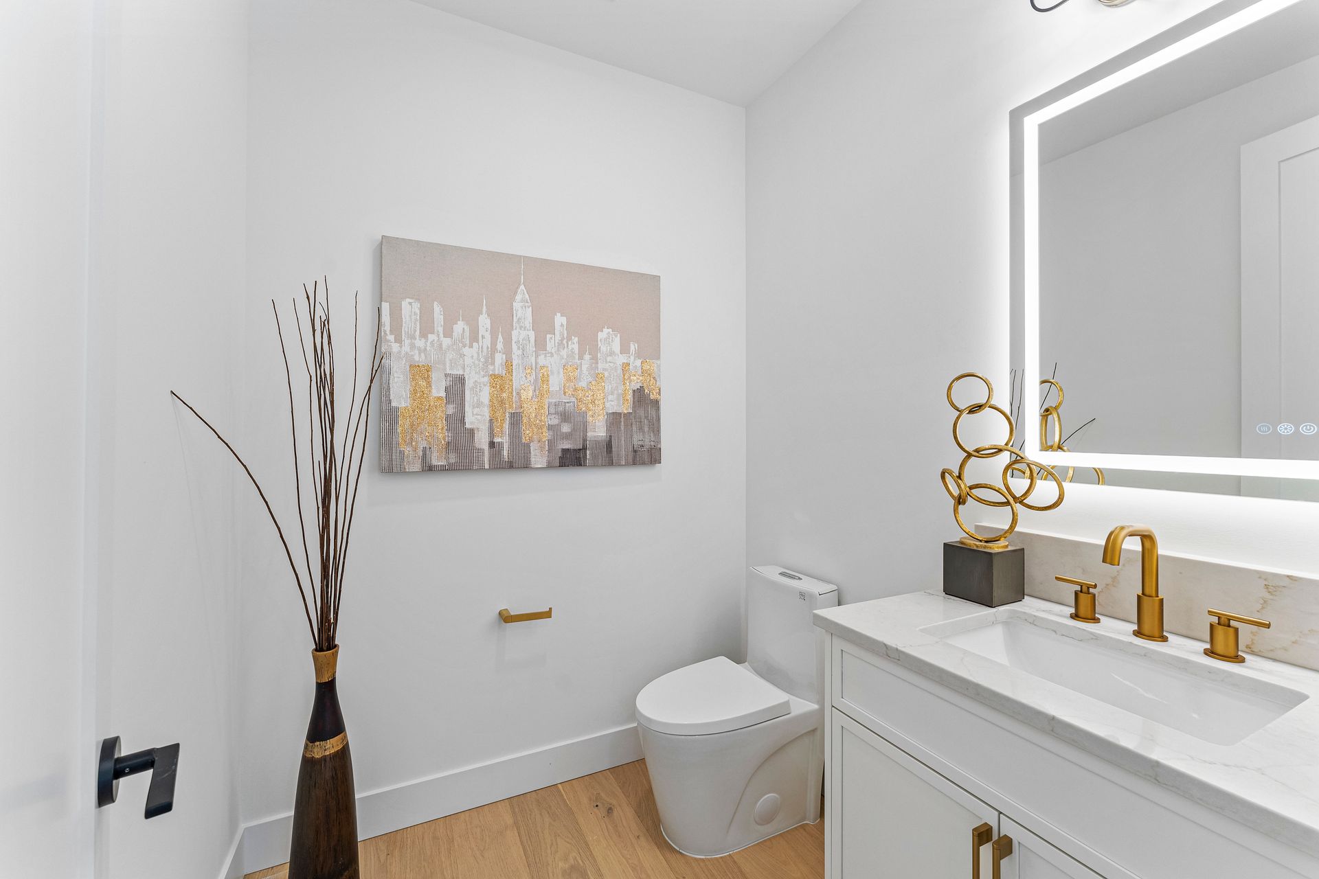 A bathroom with a toilet , sink and mirror.