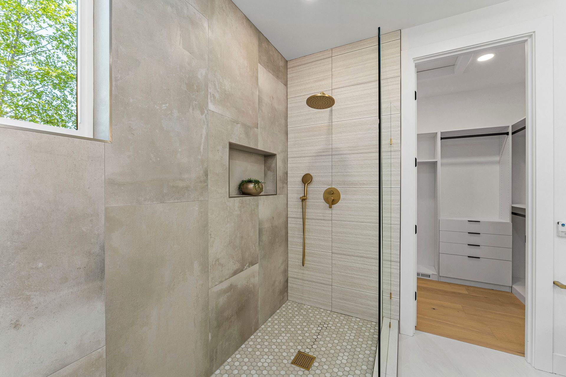 A bathroom with a walk in shower and a walk in closet.