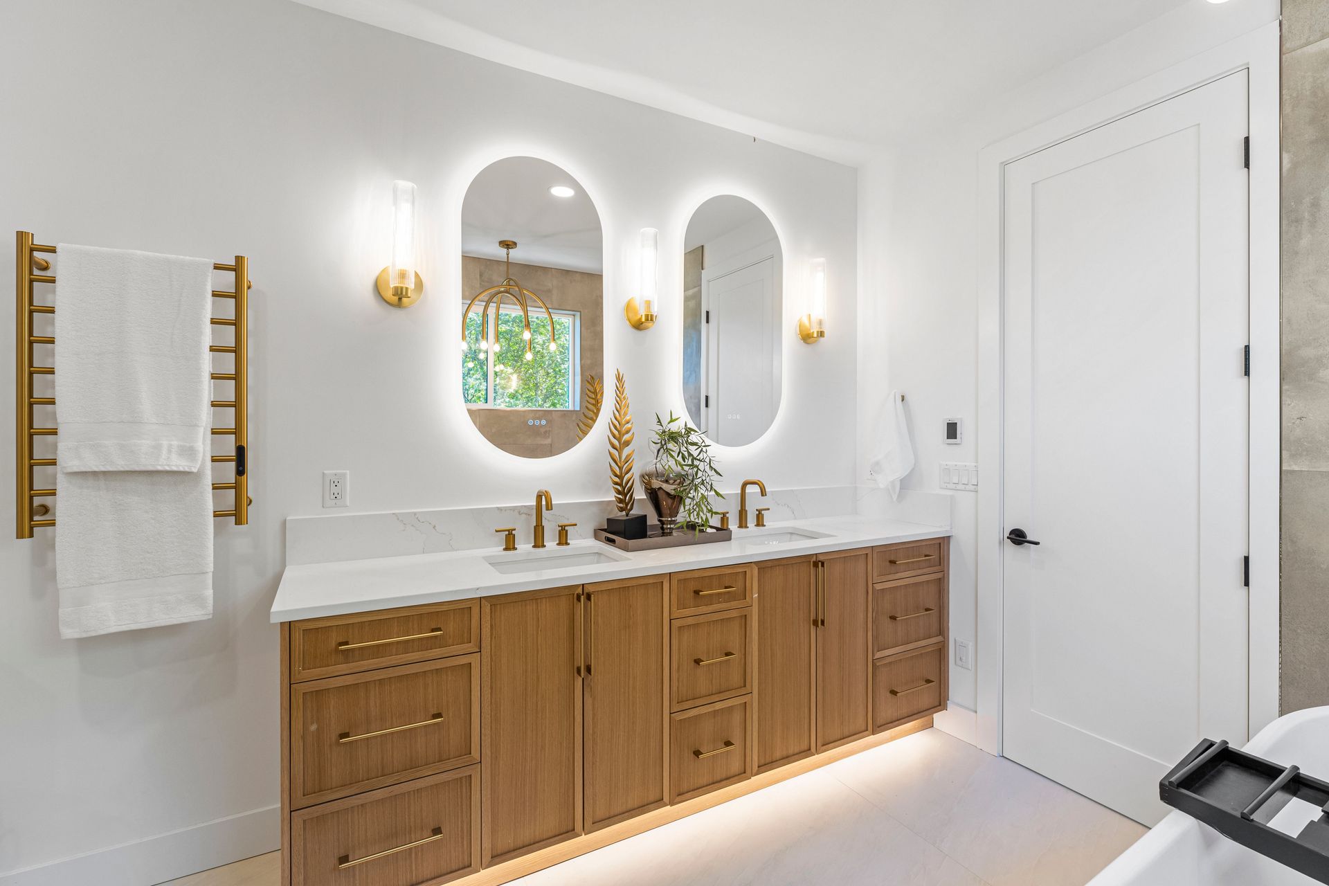 A bathroom with two sinks , two mirrors , and a bathtub.