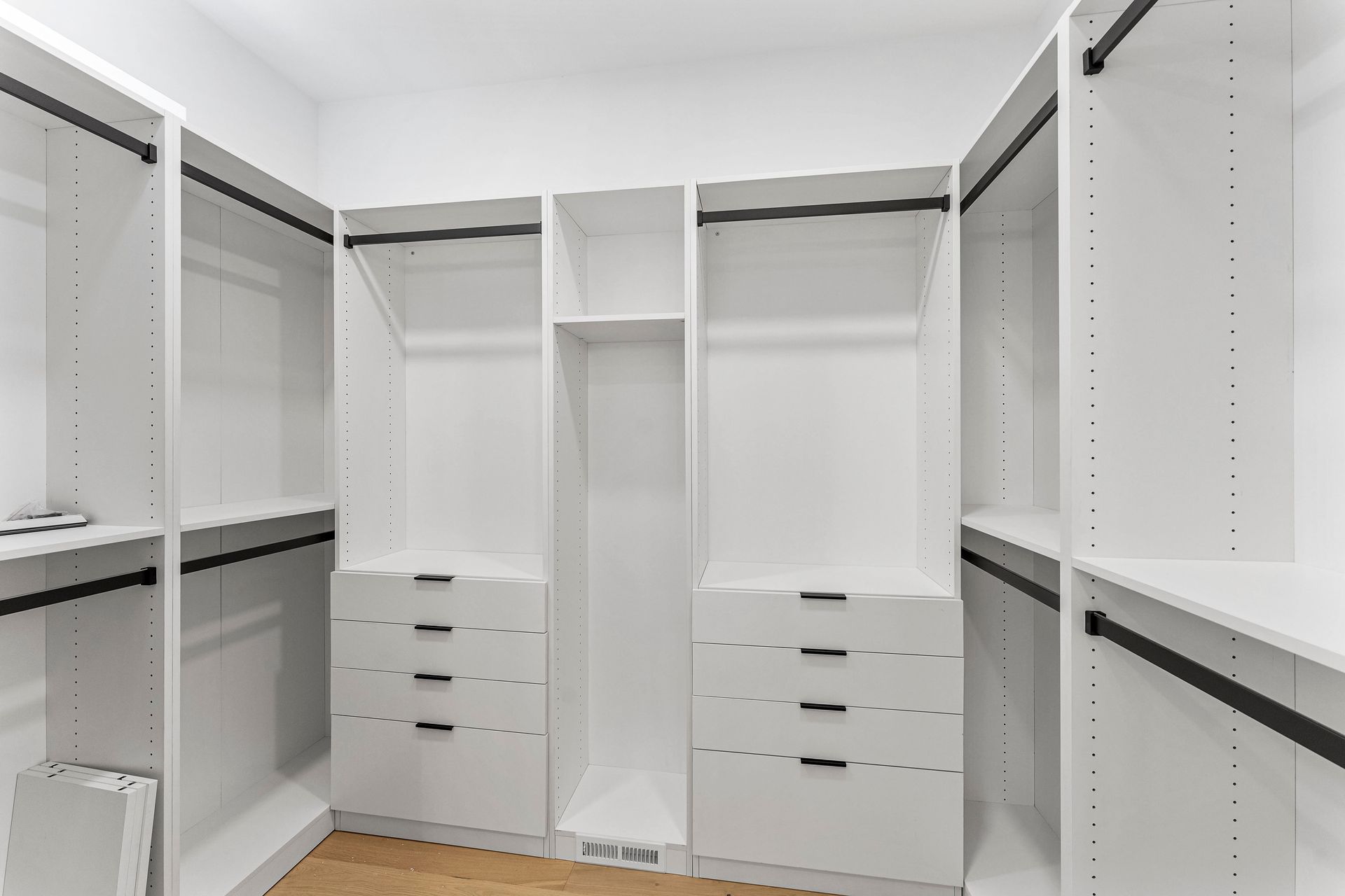 A walk in closet with lots of shelves and drawers.