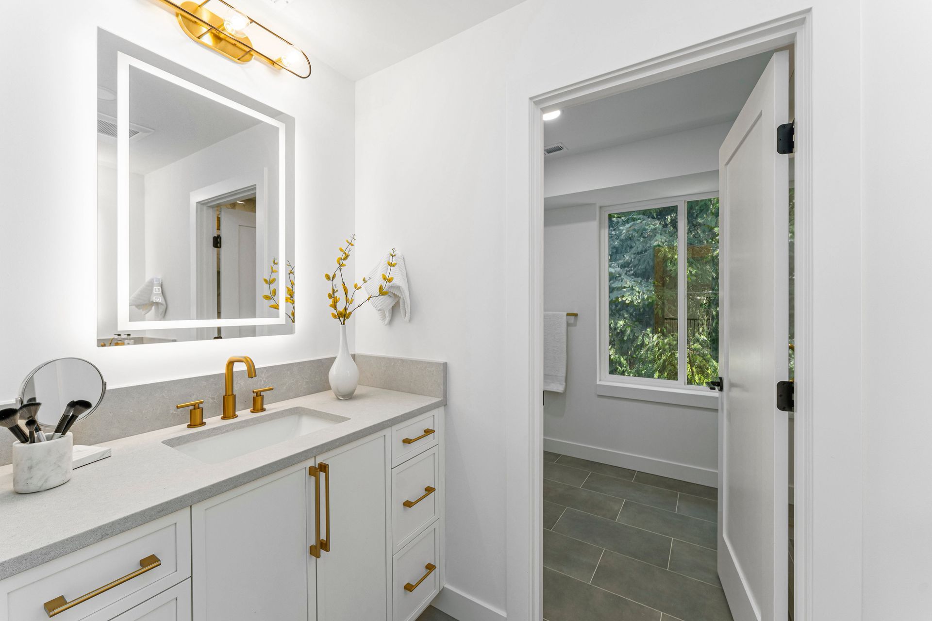 A bathroom with a sink , mirror and window.