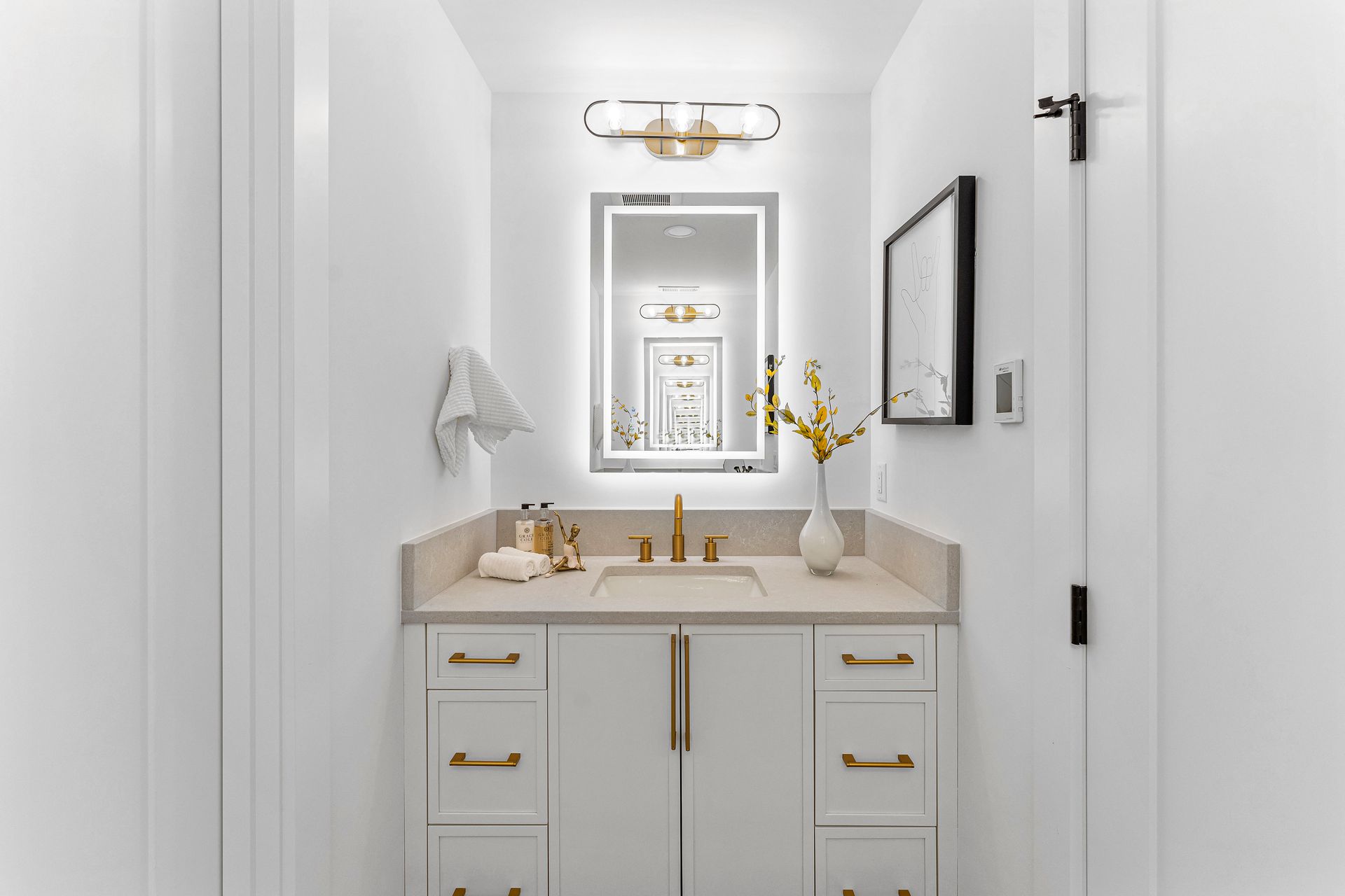 A bathroom with a sink , mirror and vanity.