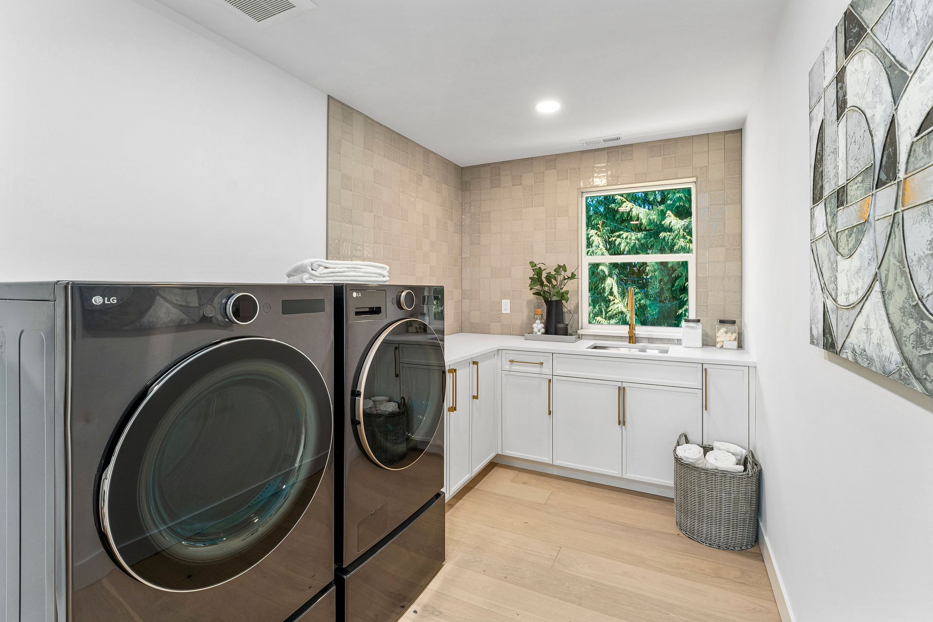 A laundry room with a washer and dryer and a sink.