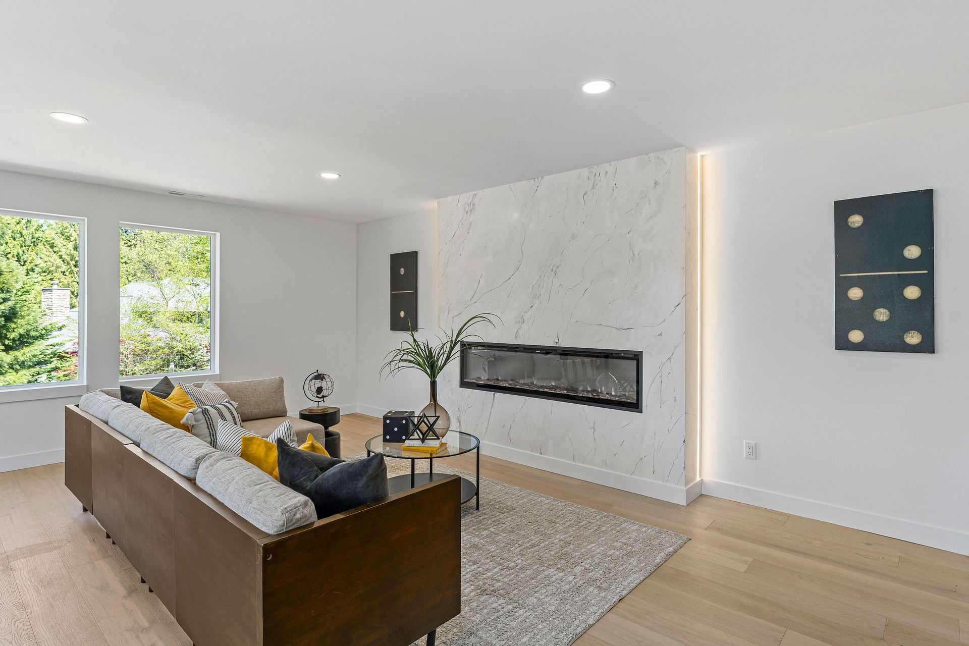 A living room with a couch , fireplace and dominoes on the wall.
