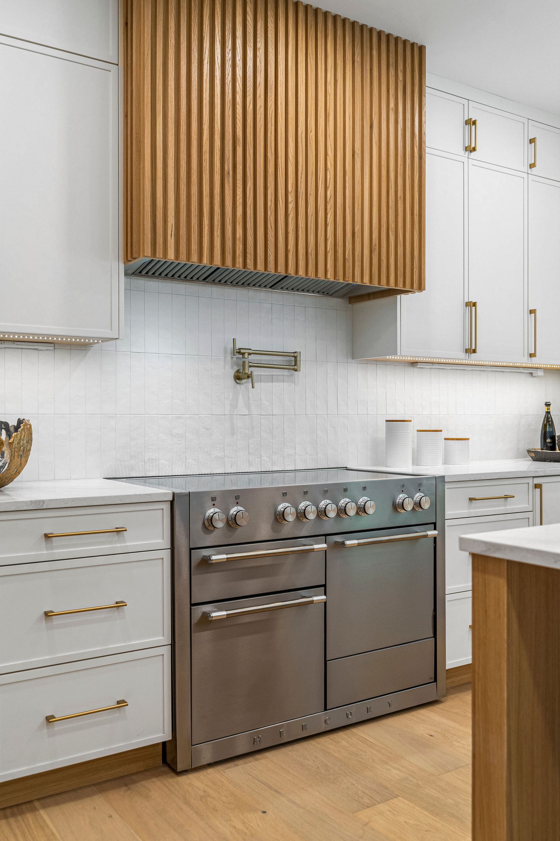A kitchen with stainless steel appliances and white cabinets.