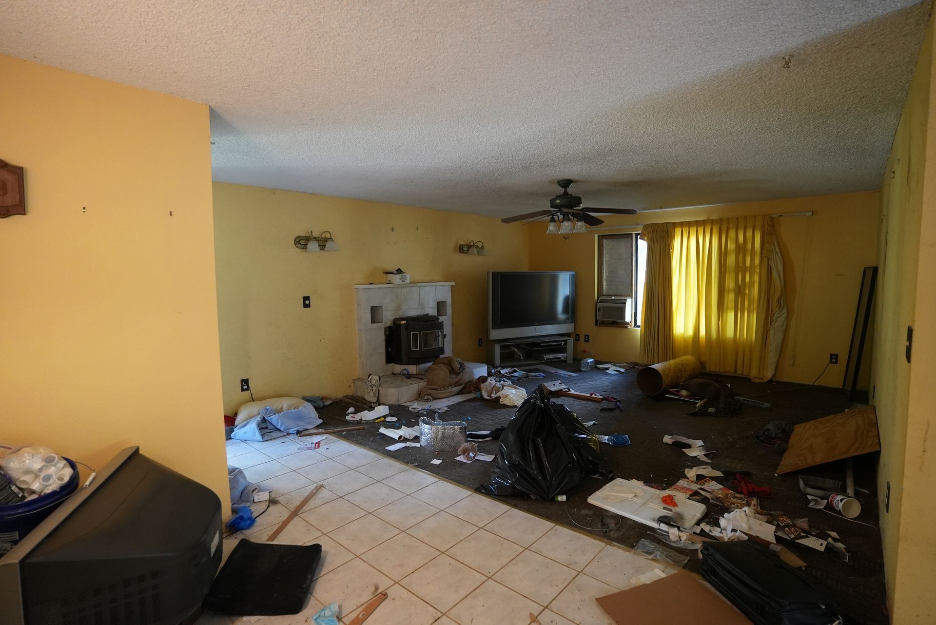 A living room with a tv and a ceiling fan
