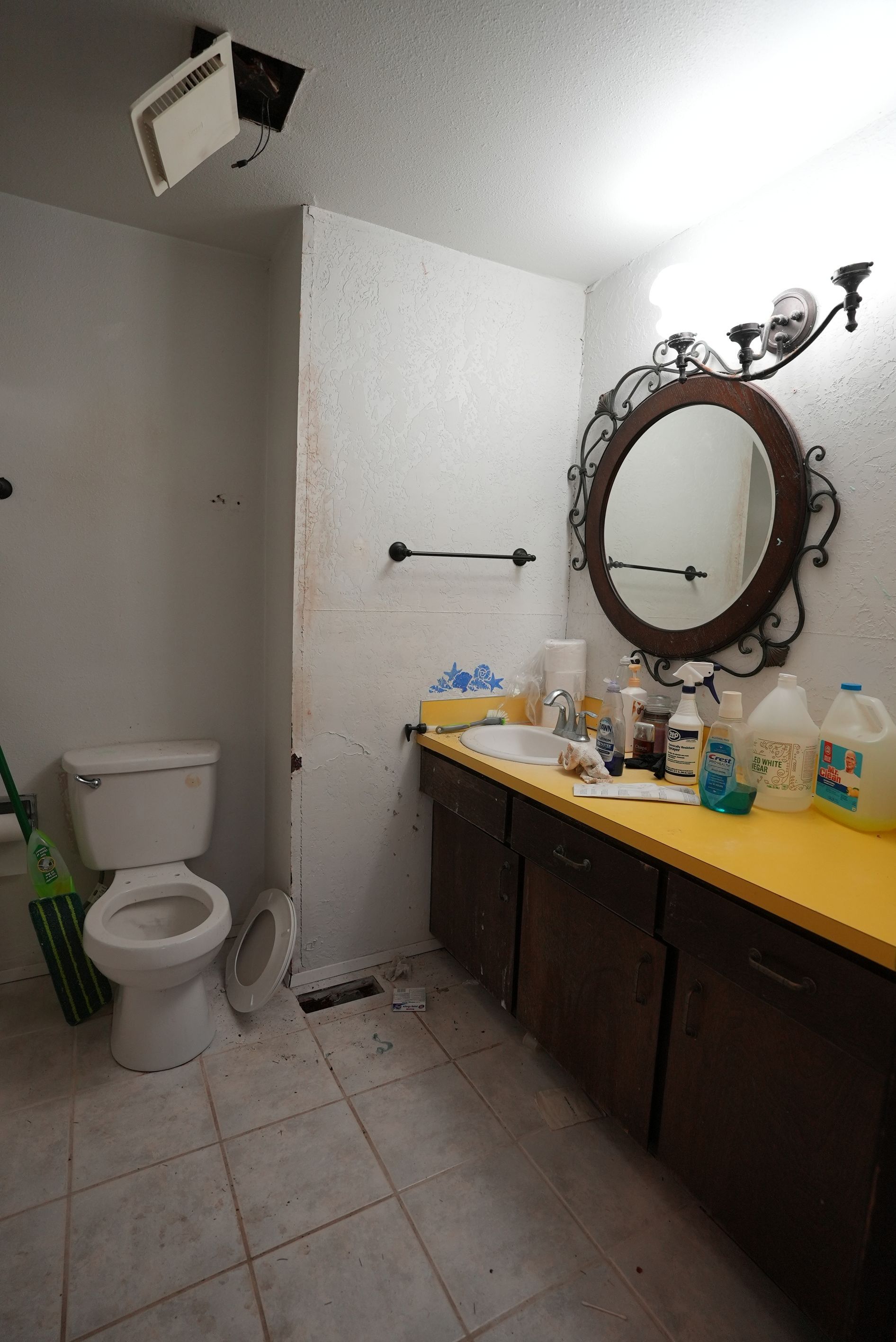 A bathroom with a toilet , sink and mirror.