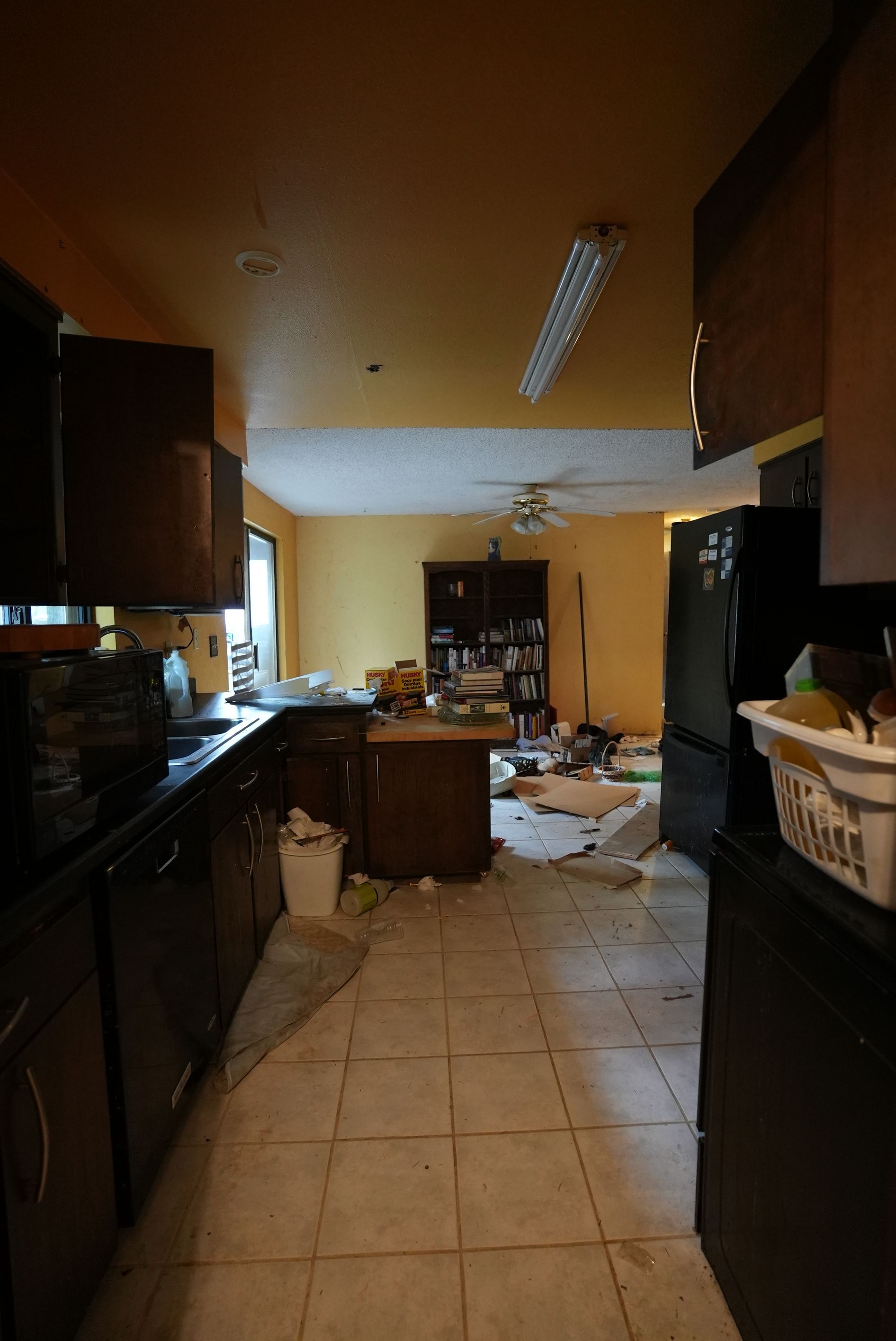 A kitchen with a black refrigerator and a laundry basket