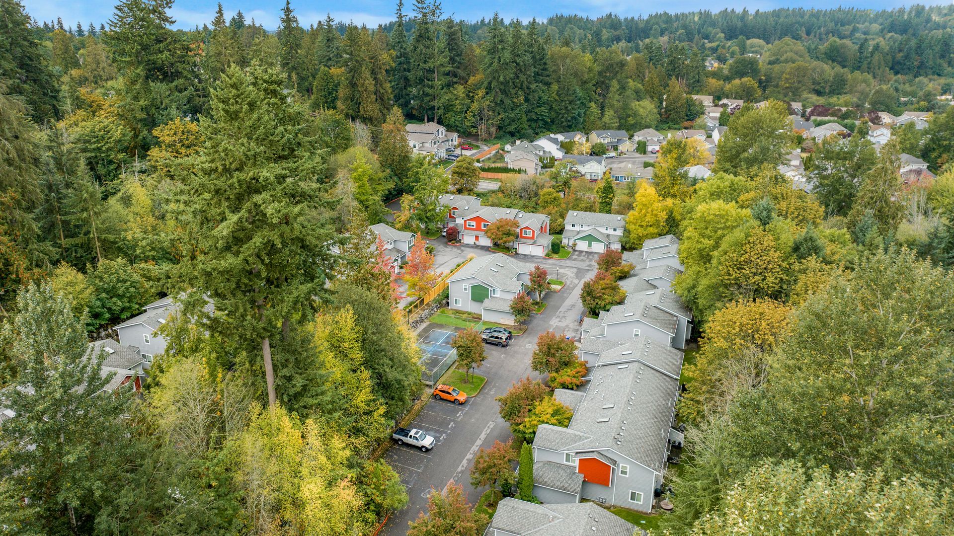 An aerial view of a residential area surrounded by trees and houses.