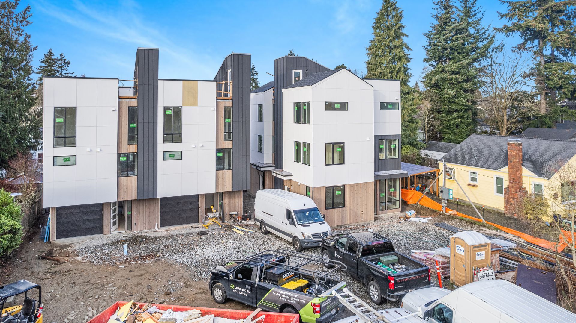 An aerial view of a building under construction with trucks parked in front of it.