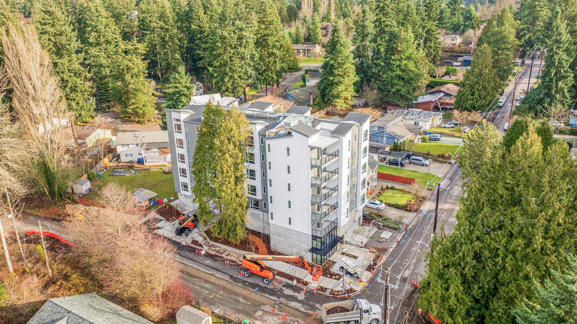 An aerial view of a building under construction in the middle of a forest.