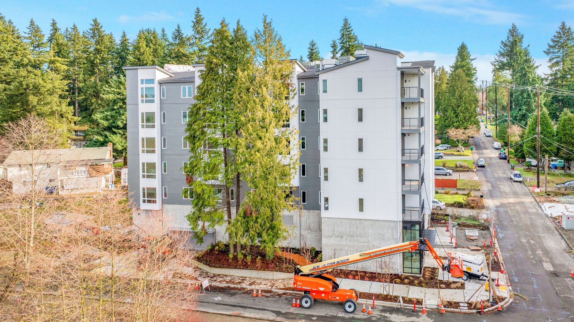 An aerial view of a building under construction in the middle of a forest.