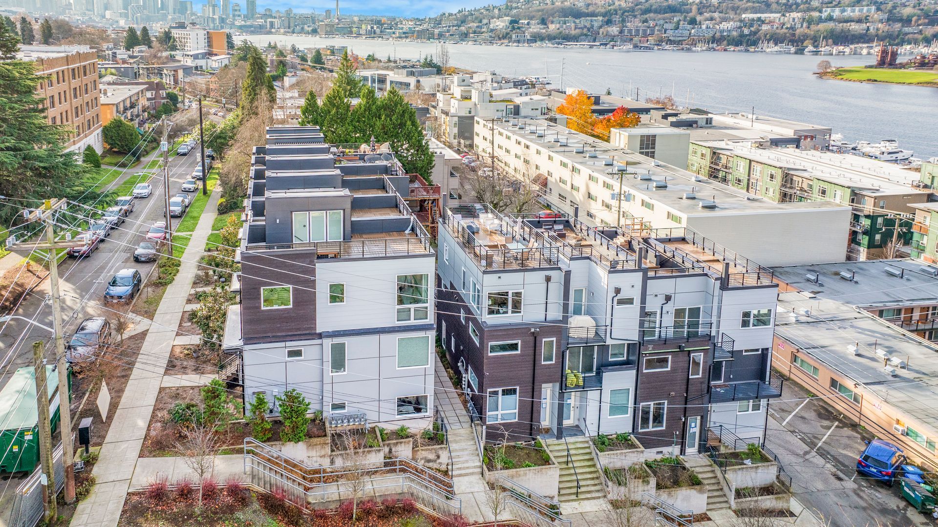 An aerial view of a city with a lot of buildings and a river in the background.