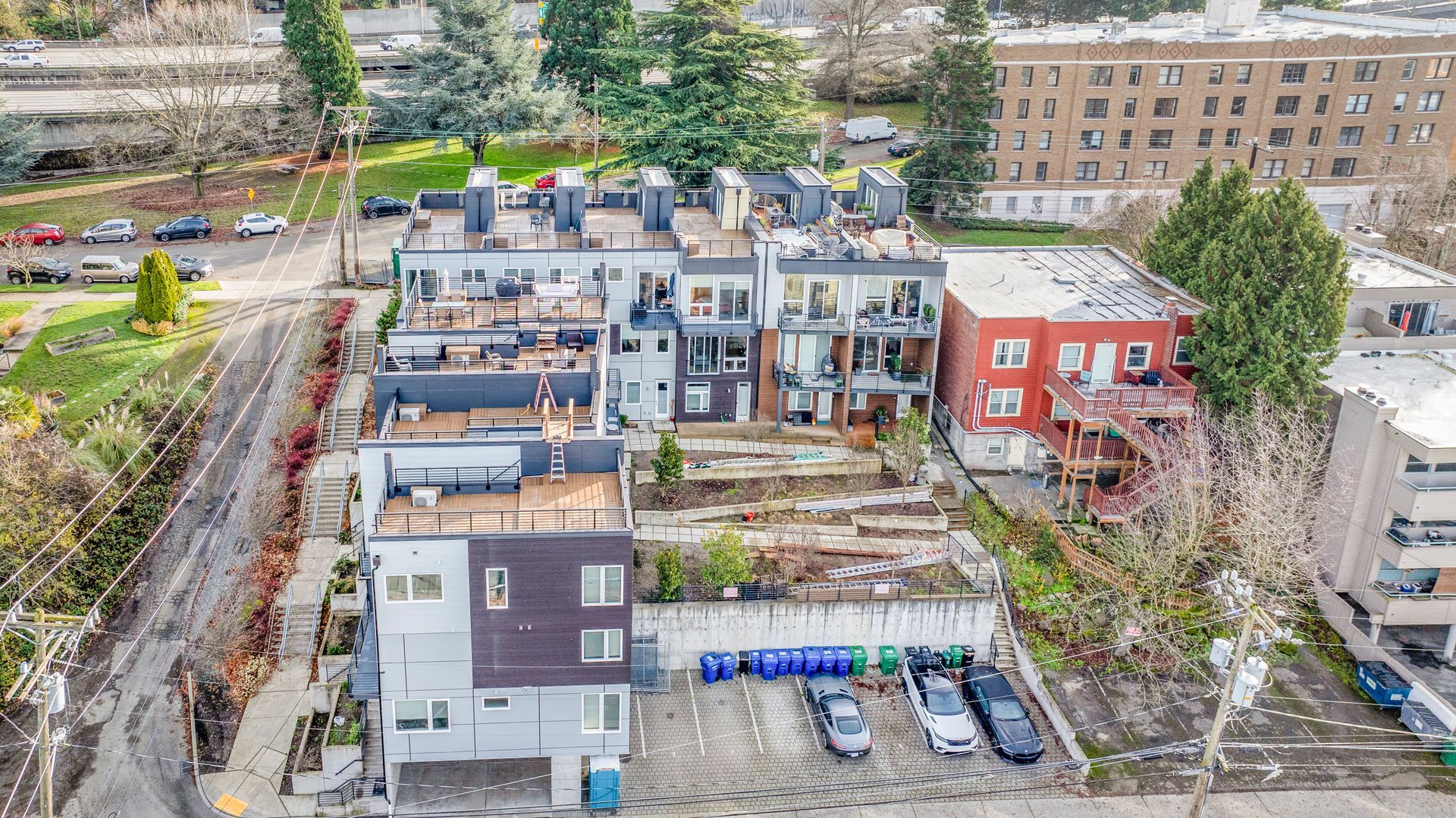 An aerial view of a building in a city with cars parked in front of it.