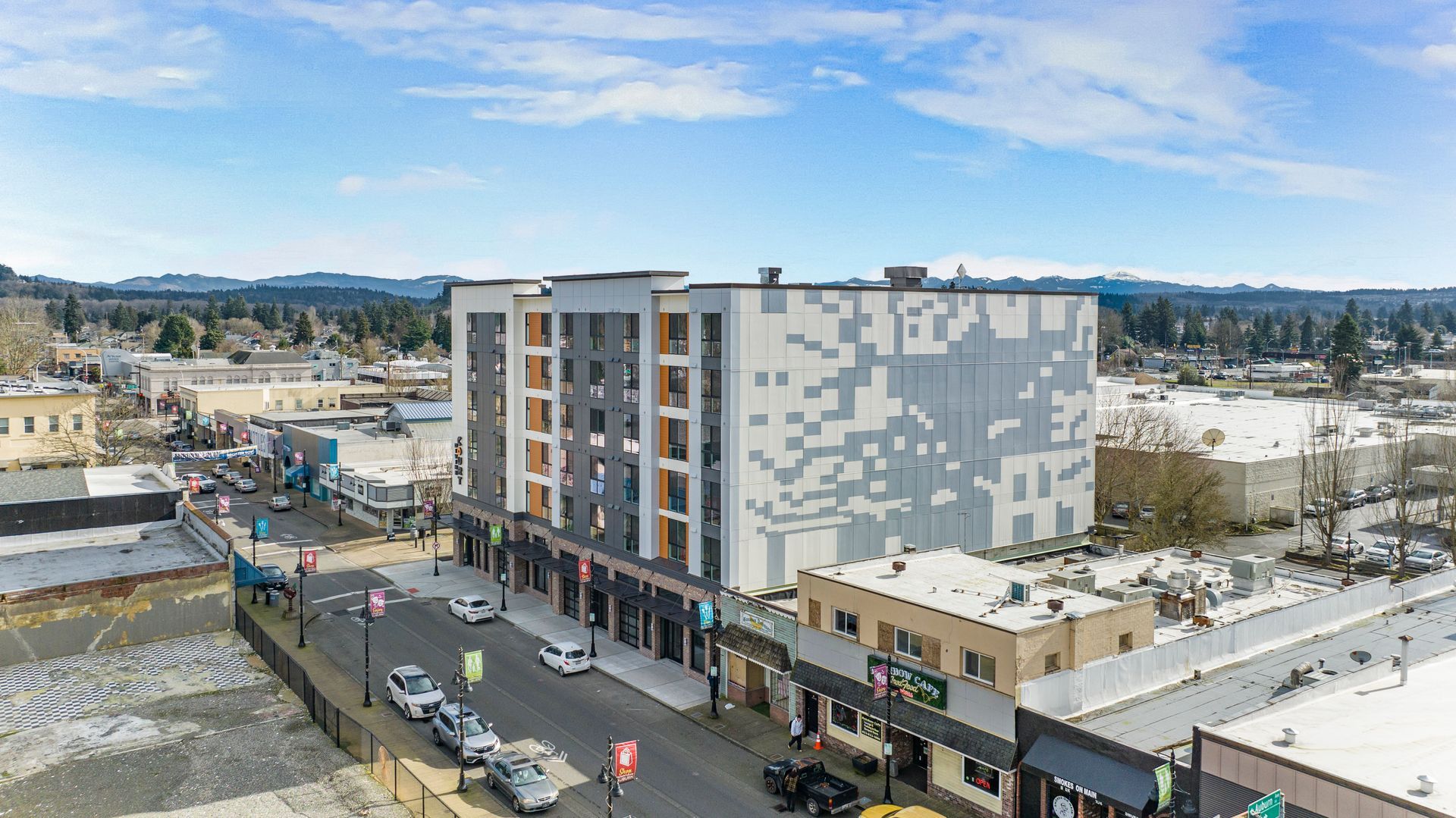 An aerial view of a city street with a large building in the background.