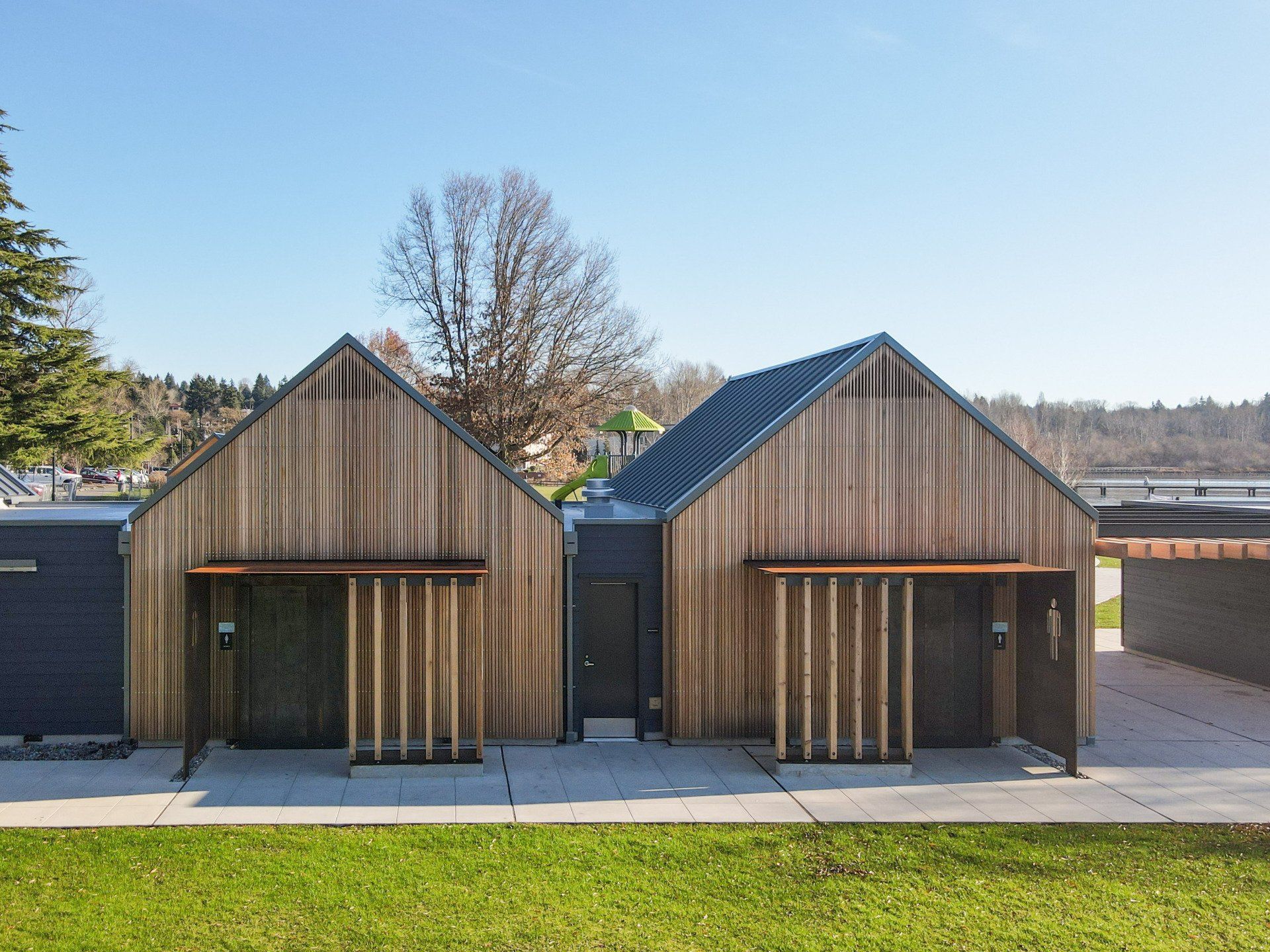 A couple of wooden houses with a roof that looks like a barn.