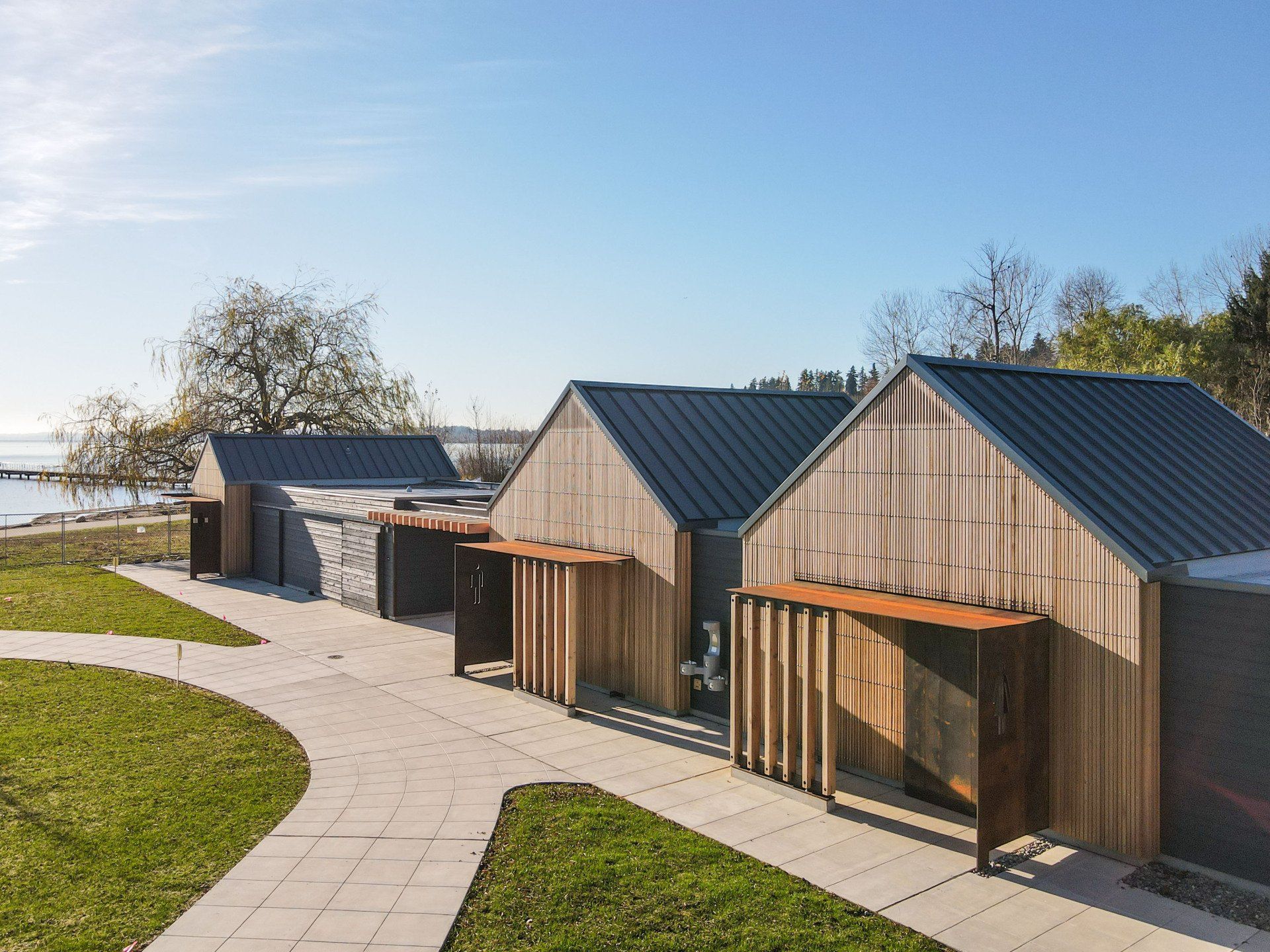A row of wooden buildings with a metal roof are lined up next to each other.